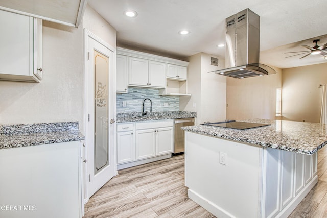 kitchen featuring sink, island exhaust hood, black electric stovetop, and white cabinetry