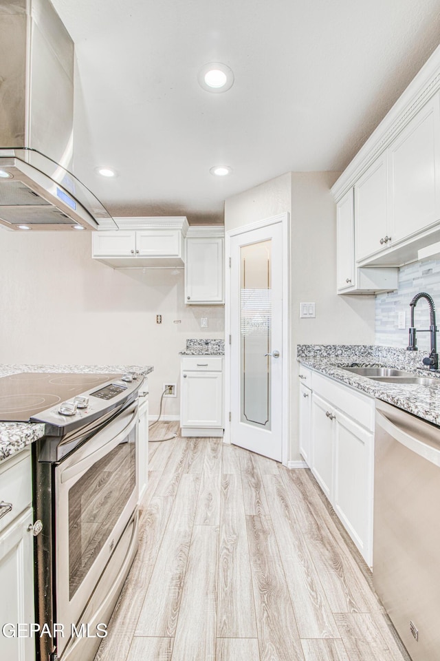 kitchen with sink, island range hood, stainless steel appliances, and white cabinetry