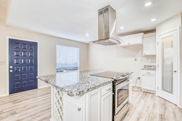 kitchen featuring white cabinetry, island range hood, light stone counters, electric range, and light hardwood / wood-style flooring