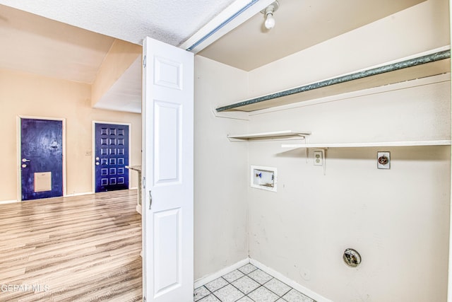 laundry area with washer hookup, a textured ceiling, hookup for a gas dryer, and hookup for an electric dryer