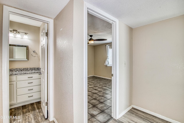 hall with a textured ceiling and hardwood / wood-style flooring