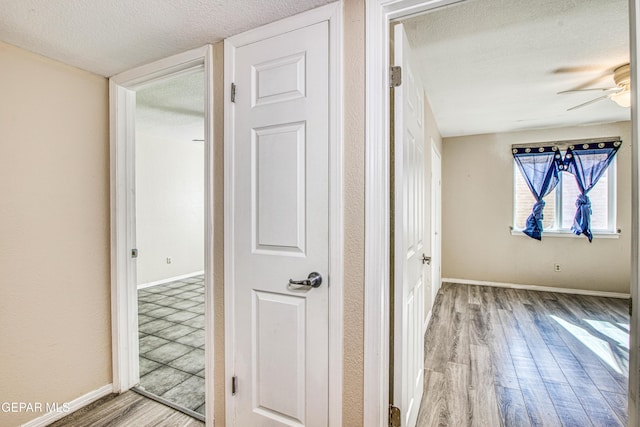 hallway featuring a textured ceiling and light hardwood / wood-style flooring