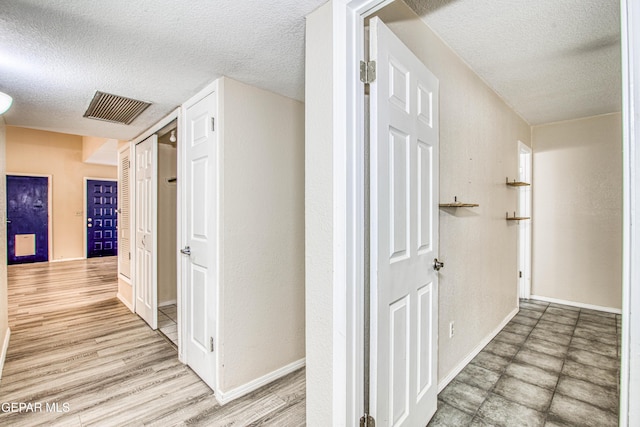 hallway with a textured ceiling