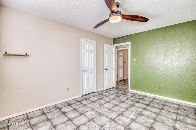 unfurnished bedroom with ceiling fan and a textured ceiling