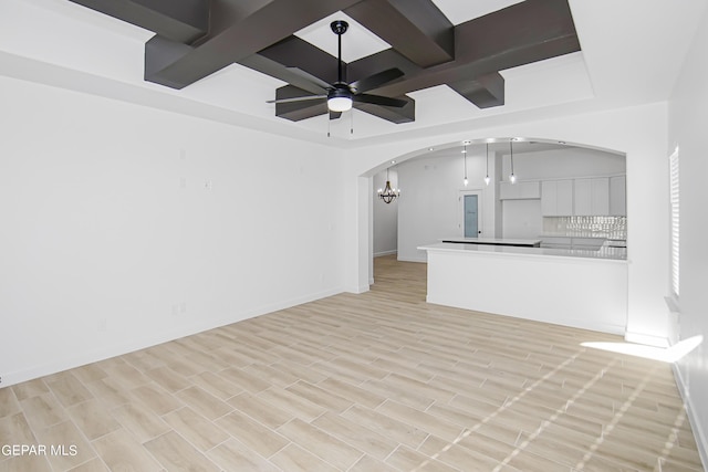 unfurnished living room with coffered ceiling, ceiling fan with notable chandelier, beam ceiling, and light hardwood / wood-style flooring