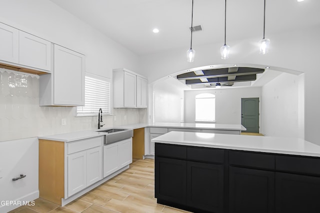 kitchen featuring sink, white cabinetry, tasteful backsplash, pendant lighting, and ceiling fan