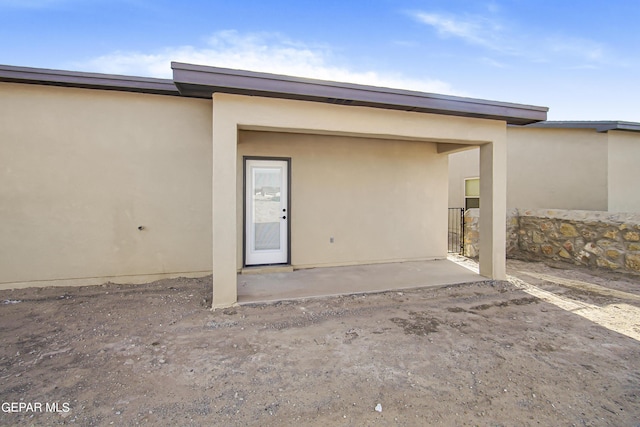 view of exterior entry with a patio