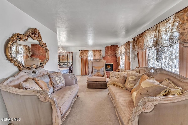 carpeted living room with a brick fireplace and an inviting chandelier