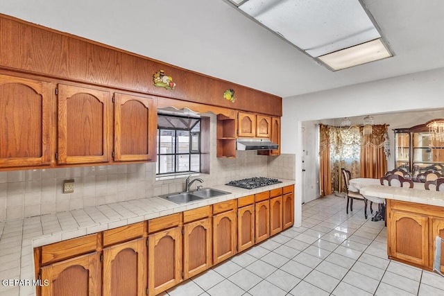 kitchen featuring sink, black gas cooktop, tasteful backsplash, and tile counters