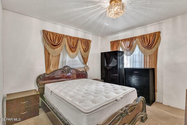 bedroom featuring carpet, an inviting chandelier, and multiple windows