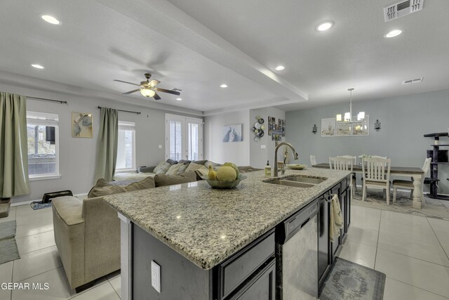 kitchen with light stone countertops, french doors, an island with sink, sink, and stainless steel dishwasher