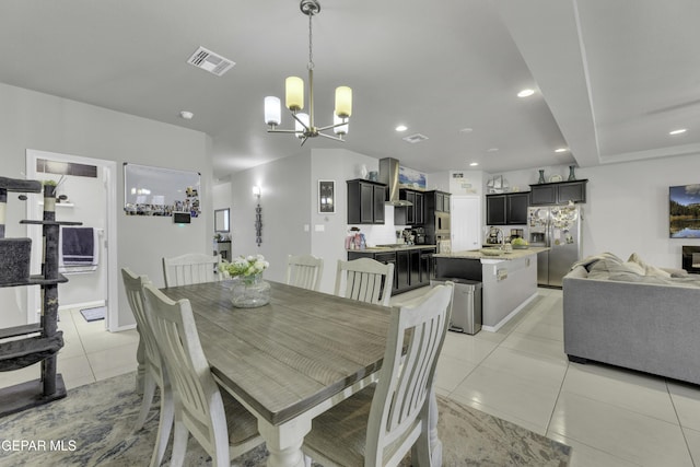 tiled dining area with sink and an inviting chandelier