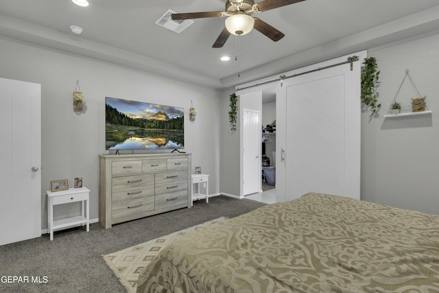 carpeted bedroom with ceiling fan and a barn door