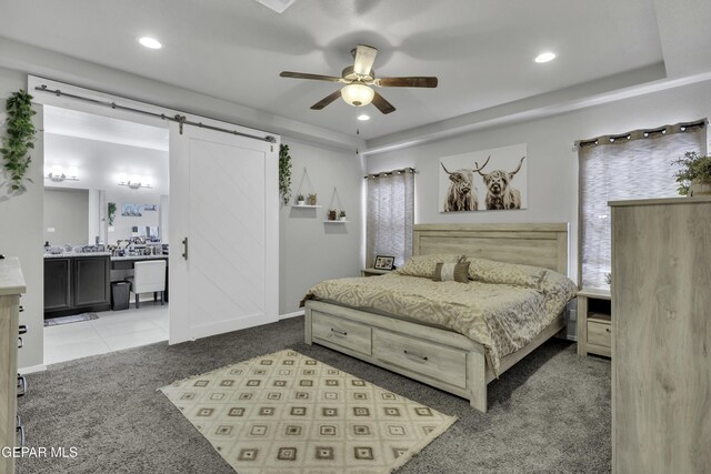 bedroom with ceiling fan, carpet, and a barn door