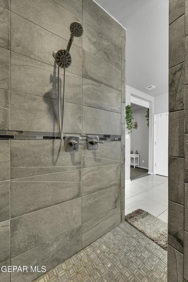 bathroom featuring tiled shower and tile patterned flooring