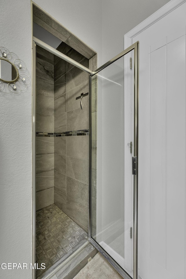 bathroom featuring a shower with door