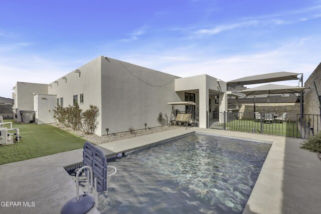 view of pool with a lawn and a patio