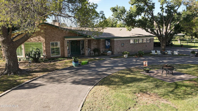 ranch-style home featuring a fire pit, a patio area, and a front yard