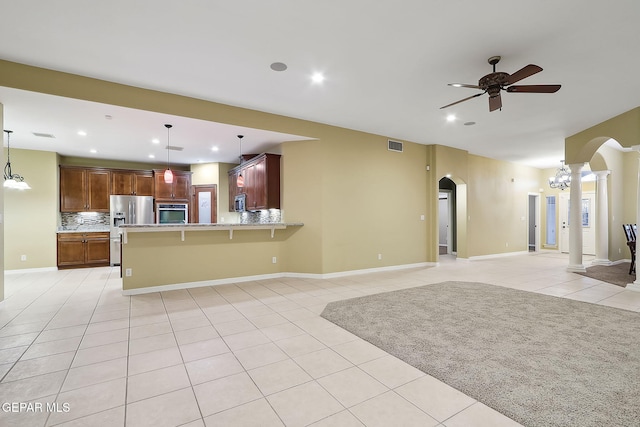 interior space featuring ceiling fan, ornate columns, and light tile patterned flooring