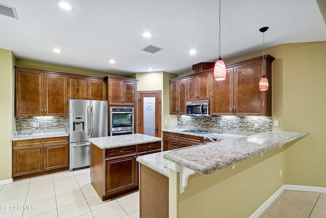 kitchen featuring decorative light fixtures, stainless steel appliances, a kitchen breakfast bar, kitchen peninsula, and light tile patterned flooring