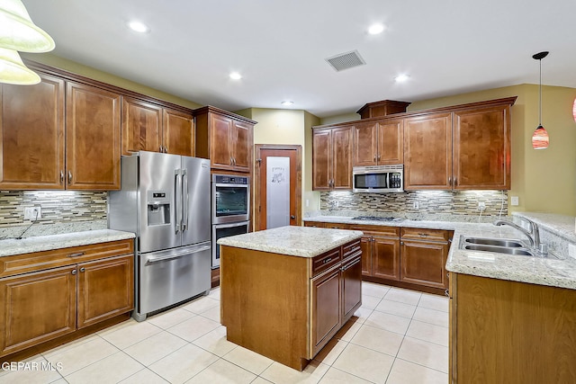 kitchen with appliances with stainless steel finishes, light tile patterned floors, sink, pendant lighting, and backsplash