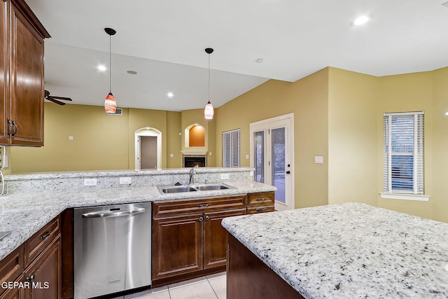 kitchen featuring light stone countertops, sink, dishwasher, and light tile patterned flooring