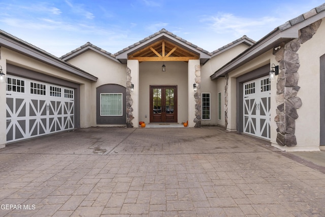 doorway to property featuring a garage and french doors