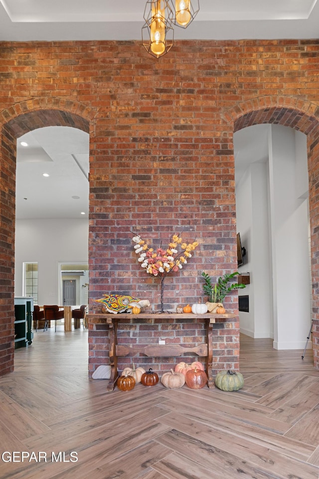 interior space featuring brick wall and parquet floors