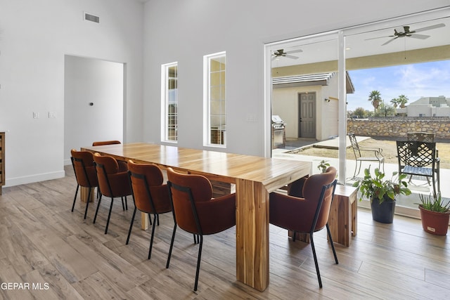 dining space with light wood-type flooring and ceiling fan