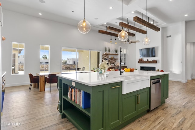 kitchen featuring decorative light fixtures, stainless steel dishwasher, a towering ceiling, and an island with sink