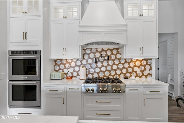 kitchen with premium range hood, white cabinets, and stainless steel appliances