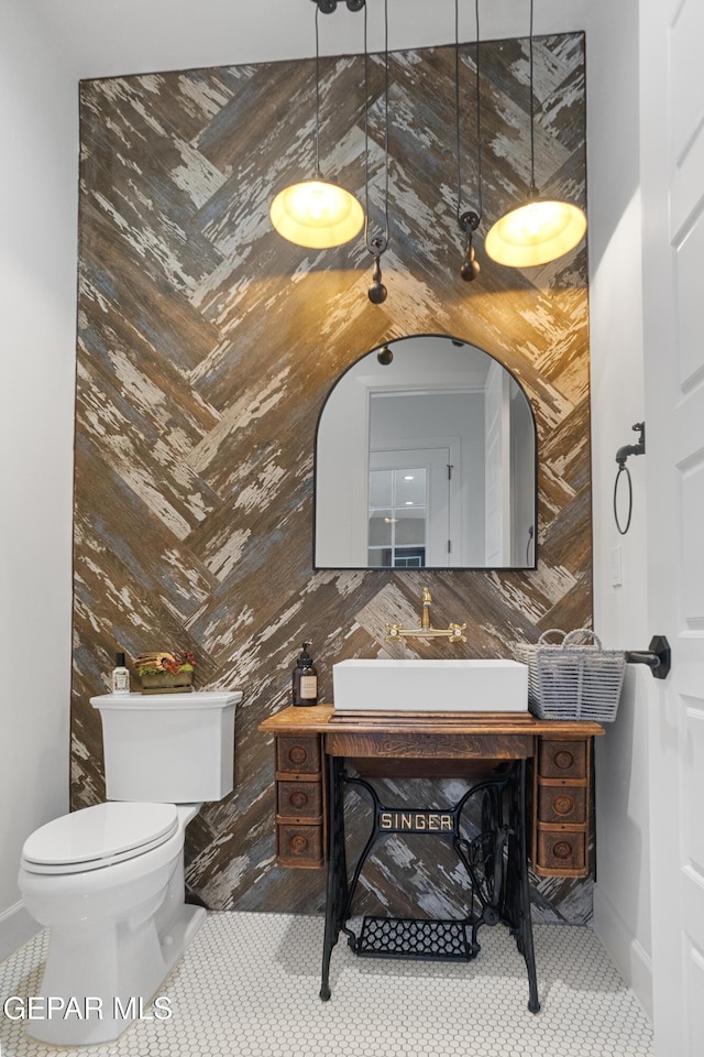 bathroom with toilet, vanity, tile patterned floors, and tile walls