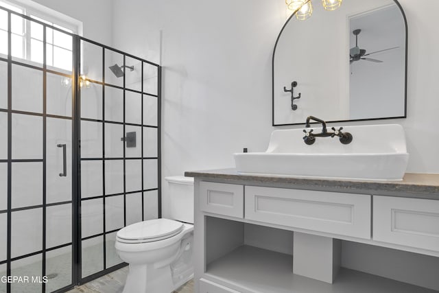 bathroom featuring vanity, toilet, ceiling fan, and tiled shower