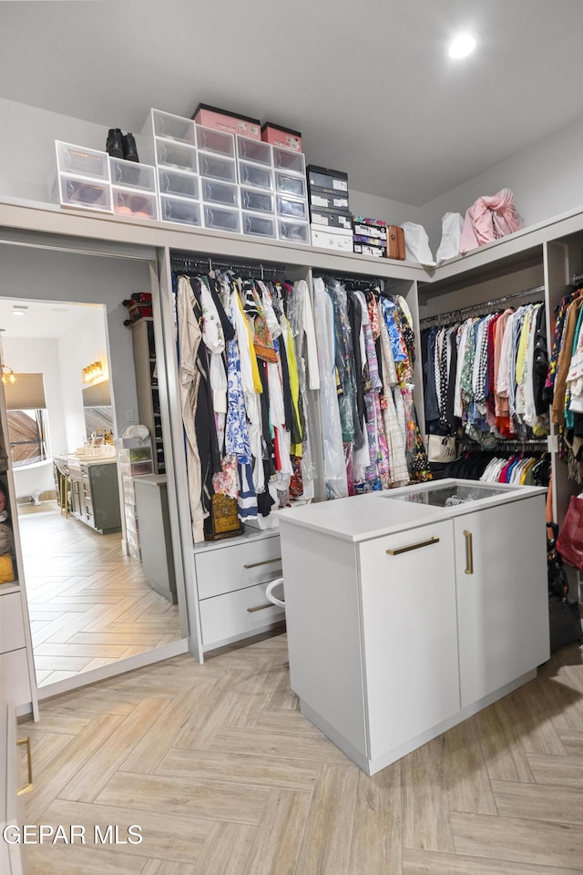 walk in closet with light parquet flooring