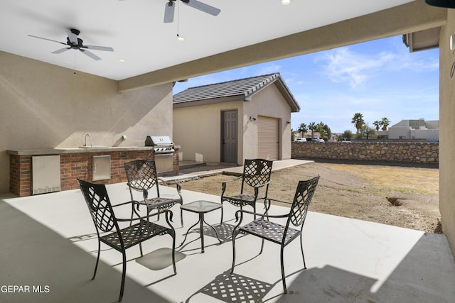 view of patio / terrace featuring sink, ceiling fan, an outdoor kitchen, and area for grilling