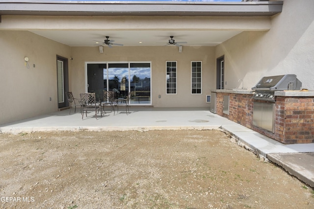 view of patio with ceiling fan, an outdoor kitchen, and a grill