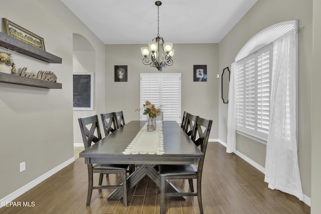 dining area with a notable chandelier and dark hardwood / wood-style flooring