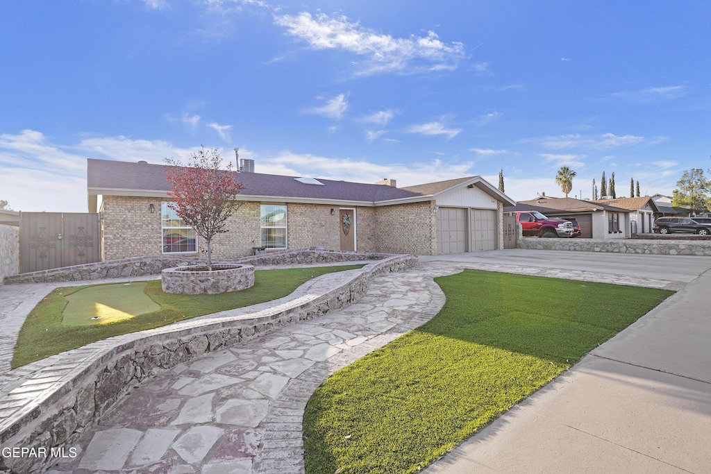 ranch-style home with a garage and a front yard