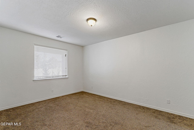 spare room featuring carpet and a textured ceiling