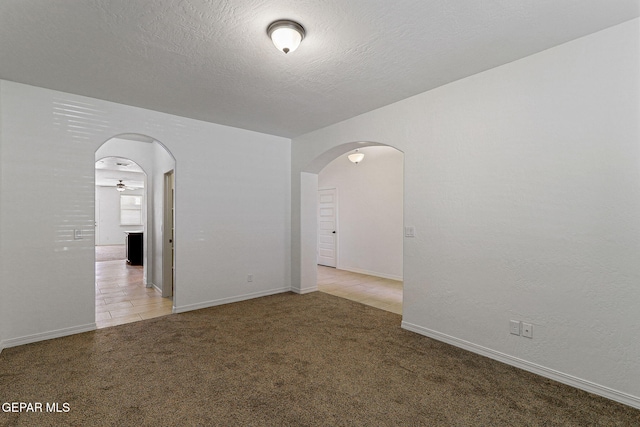 spare room featuring a textured ceiling and light carpet