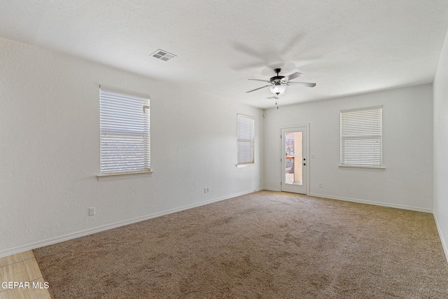 carpeted spare room featuring ceiling fan