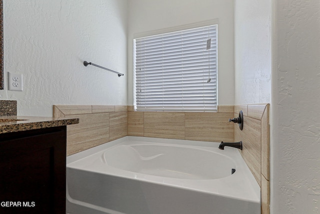 bathroom with a tub to relax in and vanity