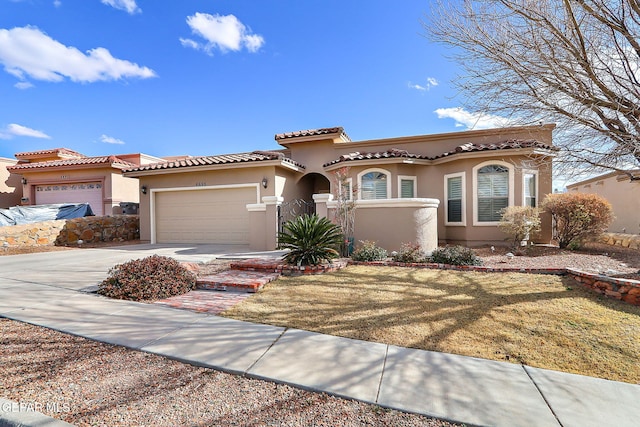 mediterranean / spanish-style home with a garage and a front yard