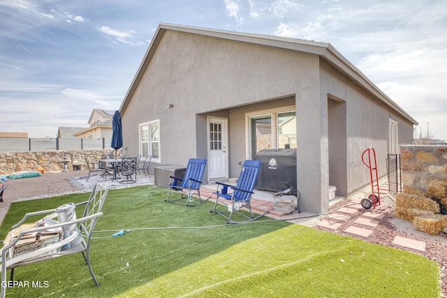 rear view of property with a lawn and a patio area