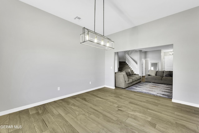 unfurnished living room featuring hardwood / wood-style floors and a chandelier