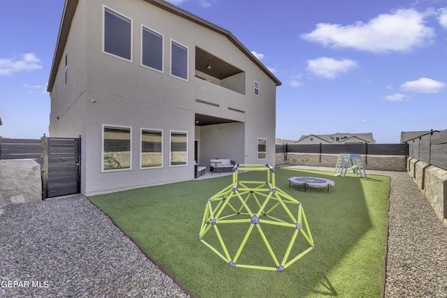 rear view of house with a playground and a yard