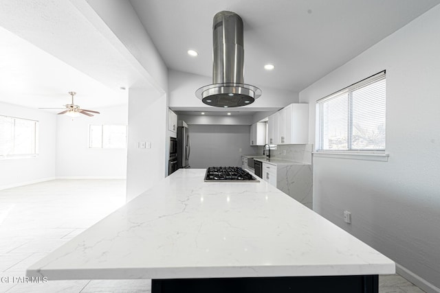 kitchen featuring sink, white cabinetry, island exhaust hood, light stone countertops, and stainless steel appliances