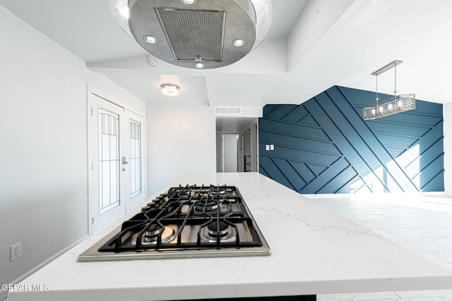 kitchen featuring decorative light fixtures, gas stovetop, and light stone counters