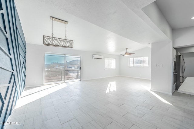 unfurnished living room featuring lofted ceiling, a textured ceiling, a wall unit AC, and ceiling fan