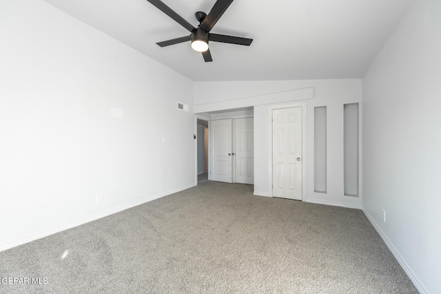 unfurnished bedroom featuring ceiling fan, carpet flooring, and vaulted ceiling